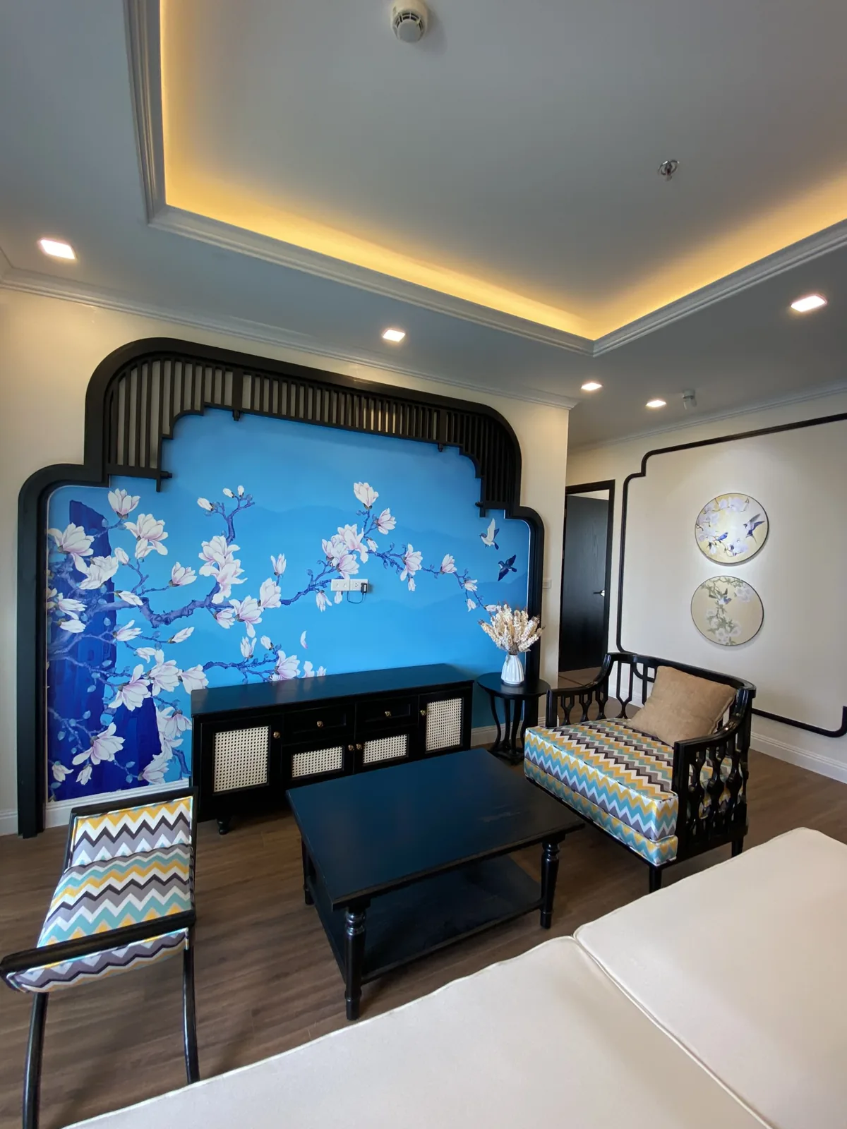 Phòng khách Indochine với mảng tường mộc lan xanh và khung gỗ đen uốn vòm